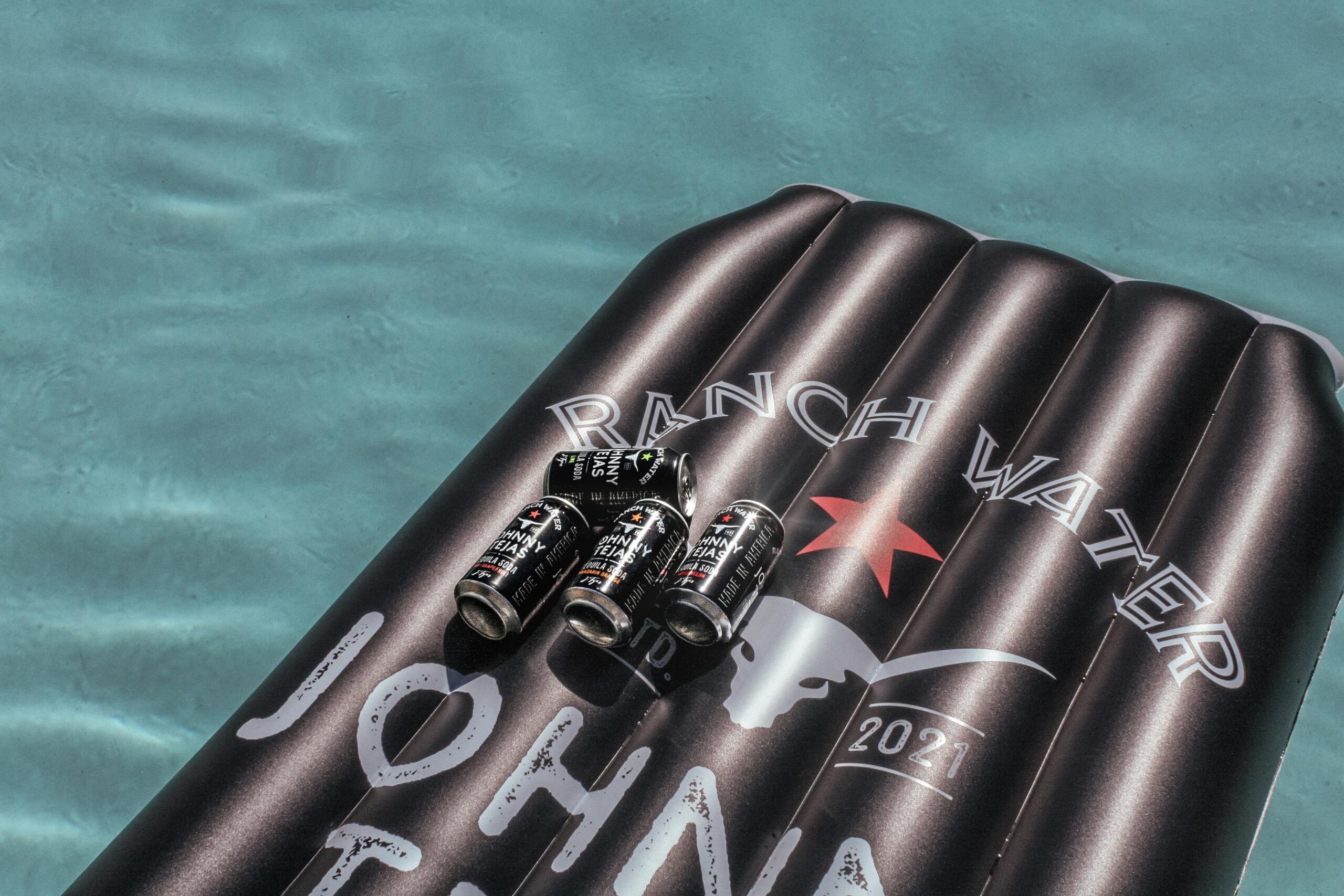 4 Johnny Tejas Cans on a Johnny Tejas Float in a pool
